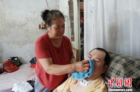 每次喂完食物后，梁青蘭都要仔細(xì)地幫兒子清理干凈?！∩忻鱾b 攝