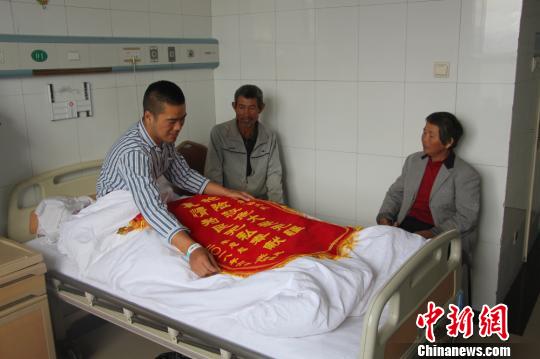 被救的李忠起、張總鳳夫婦看望受傷后的李運(yùn)飛。　汪渝 攝