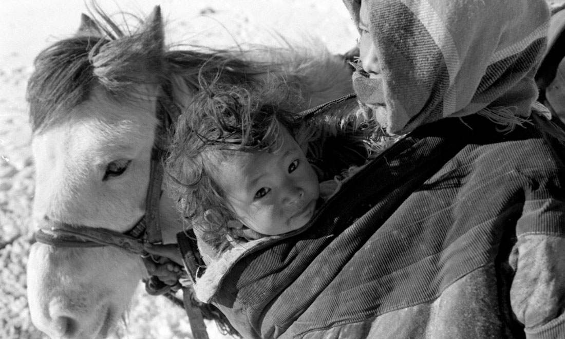 1990年3月，西藏當(dāng)雄縣納木湖鄉(xiāng)三村女牧民斯卓不畏嚴(yán)寒，懷抱幼子，準(zhǔn)備到遠(yuǎn)處放牧。新華社記者覺(jué)果攝