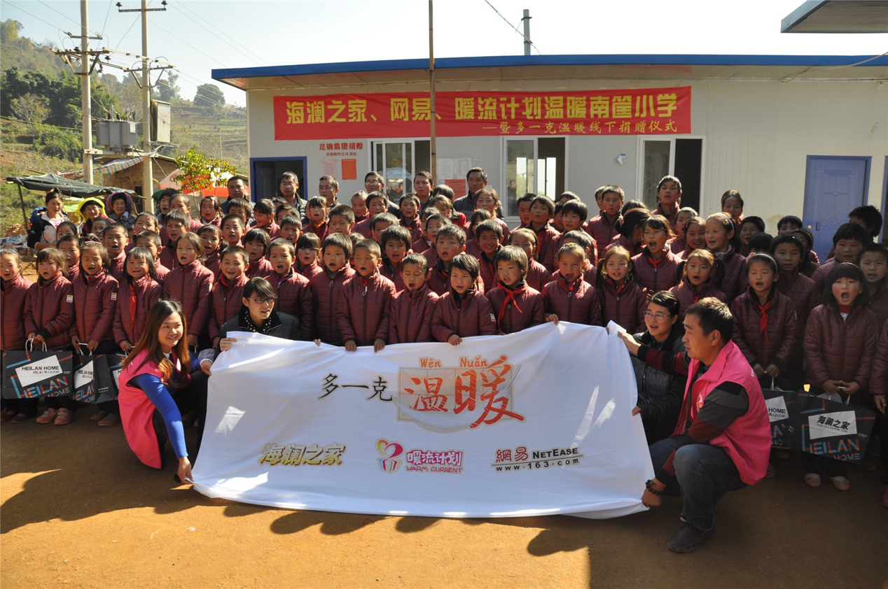 2014年11月20日，&ldquo;多一克溫暖&rdquo;公益團隊來到8.3大地震的重災區(qū)&mdash;&mdash;云南省昭通市魯?shù)榭h的南筐小學。越過崎嶇山路，將一批又一批暖心羽絨服送到了師生們的手中，也將社會的關懷和愛意傳遞給了這些可愛的人。